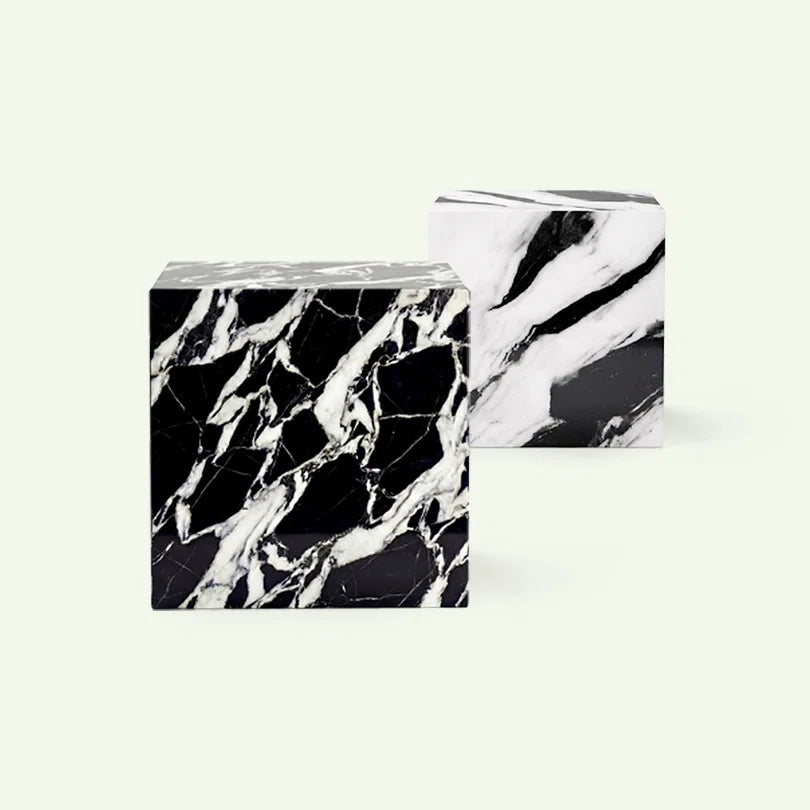 Kollektionsübersicht der Gonia Serie. Im Fokus steht die Variante aus tiefschwarzem Grande Antique Marmor mit markanten weißen Fragmenten, im Hintergrund ist das Modell in Panda White Marmor zu sehen.