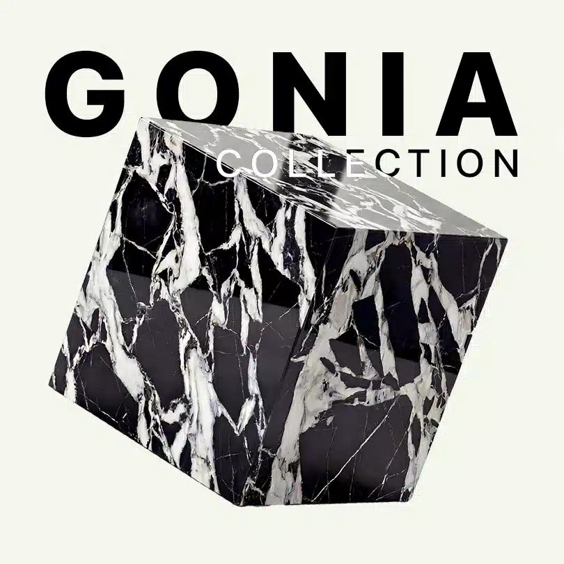 Werbegrafik für den Gonia Beistelltisch von Menelame aus Grande Antique Marmor. Das Bild zeigt den würfelförmigen Tisch mit seiner dramatischen schwarz-weißen Brekzien-Struktur vor dem „Gonia Collection“ Schriftzug.