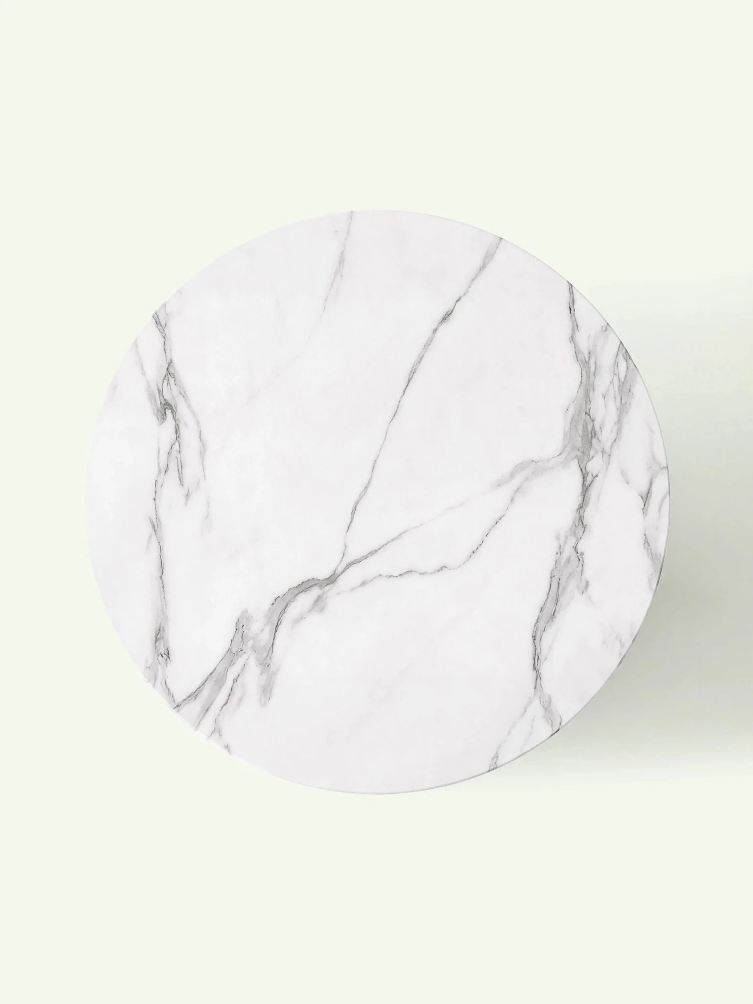 Blick von oben auf die kreisrunde Tischplatte aus Calacatta White Marmor mit dezenten, natürlichen grauen Linien.