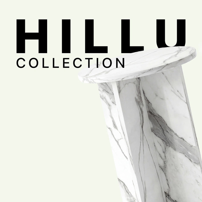 Werbegrafik für den Hillu Beistelltisch aus weißem Calacatta Marmor. Das Bild zeigt eine Nahaufnahme der eleganten Tischplatte und des markant gekreuzten Standfußes vor dem „Hillu Collection“ Schriftzug.