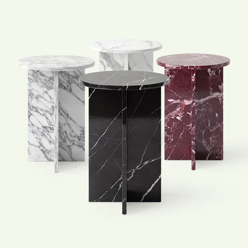 Frontale Kollektionsübersicht der Hillu Serie. Im Zentrum steht die Ausführung in tiefschwarzem Nero Marquina Marmor, flankiert von den Modellen in Arabescato, Calacatta White und Rosso Levanto zur Veranschaulichung der Materialauswahl.