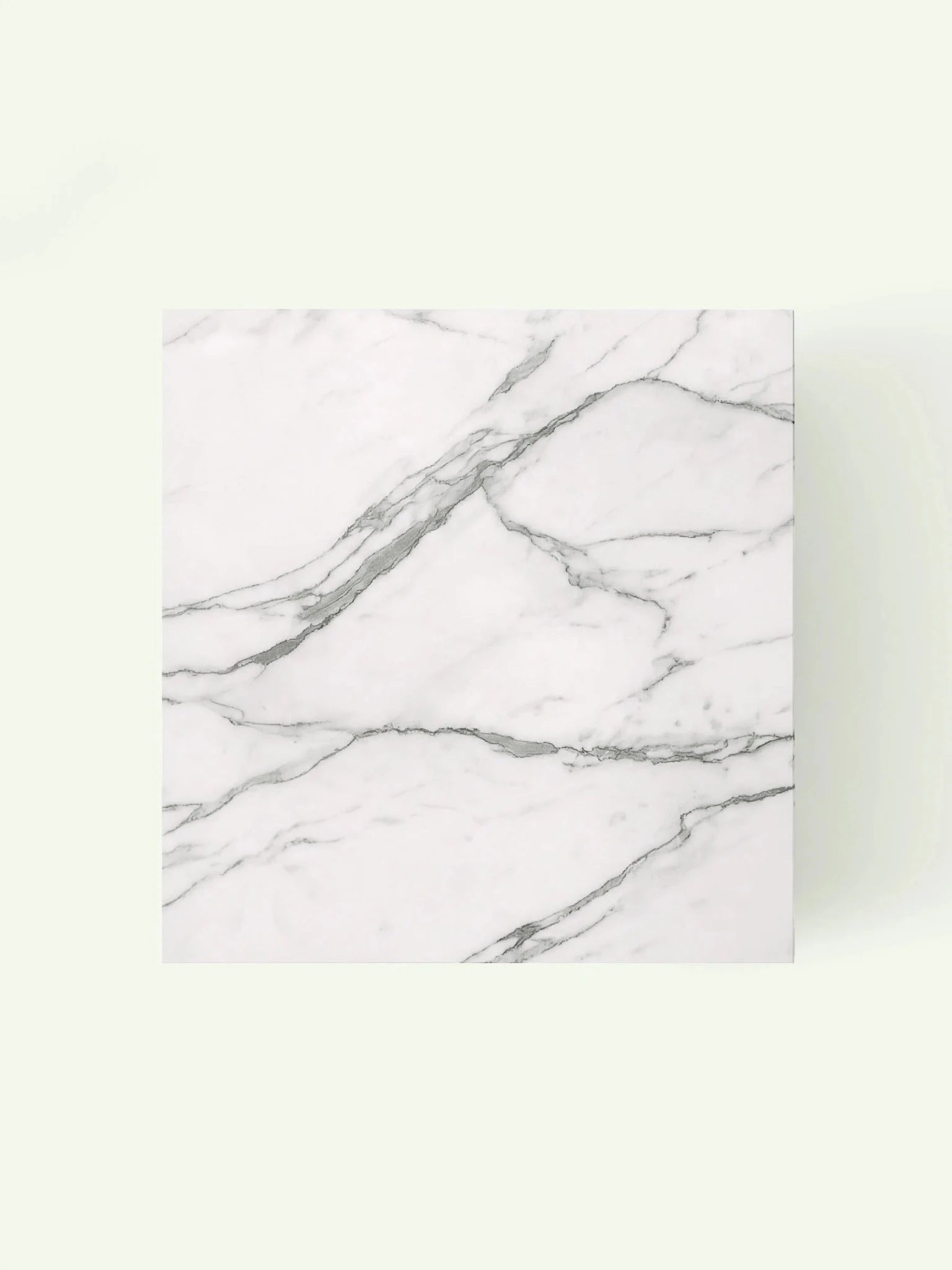 Blick direkt von oben auf die quadratische Tischplatte aus Calacatta White Marmor mit natürlicher Linienführung.