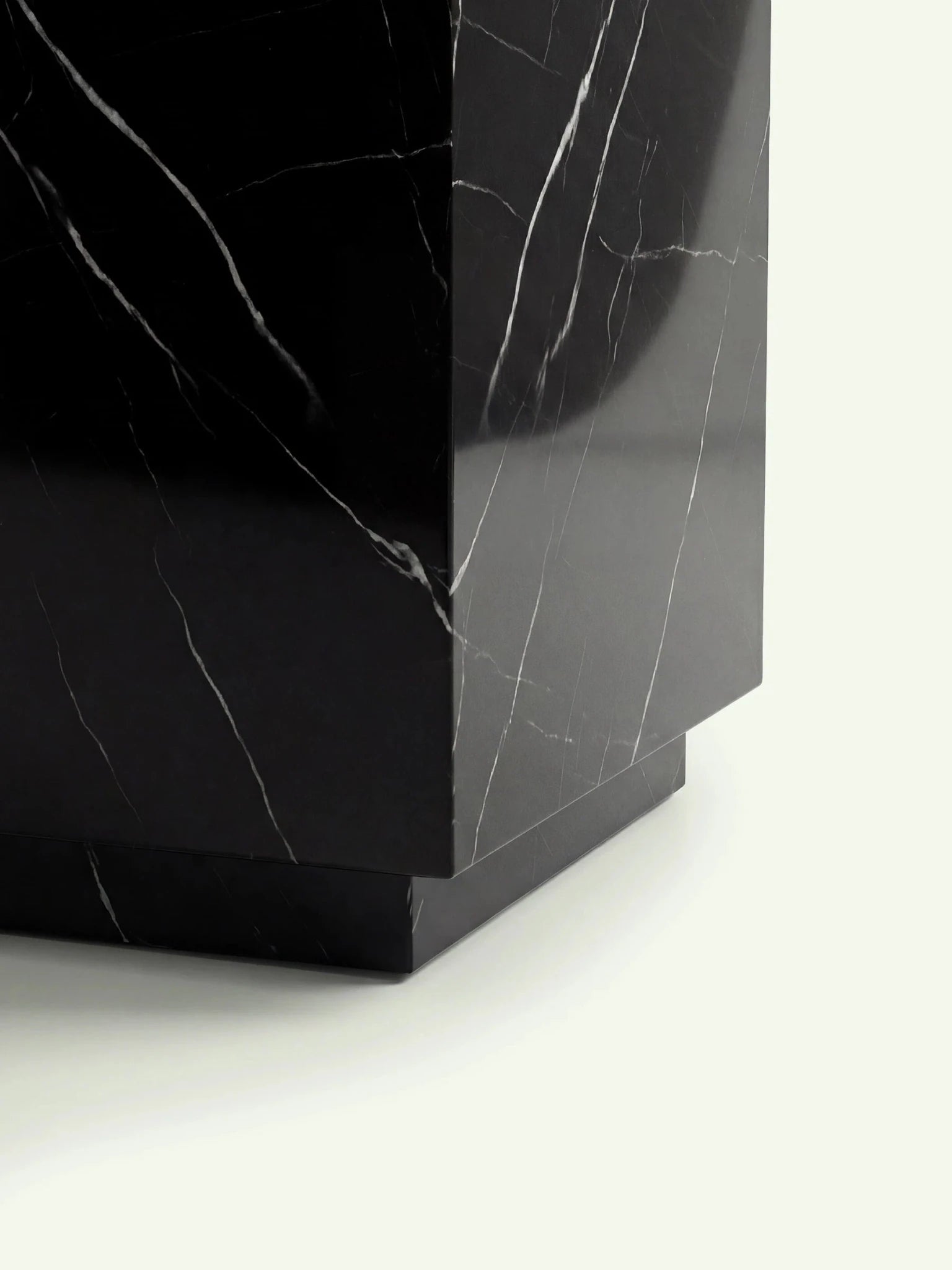Detailansicht des unteren Bereichs des Tisches Pella mit Fokus auf den eingerückten Sockel aus Nero Marquina Marmor.