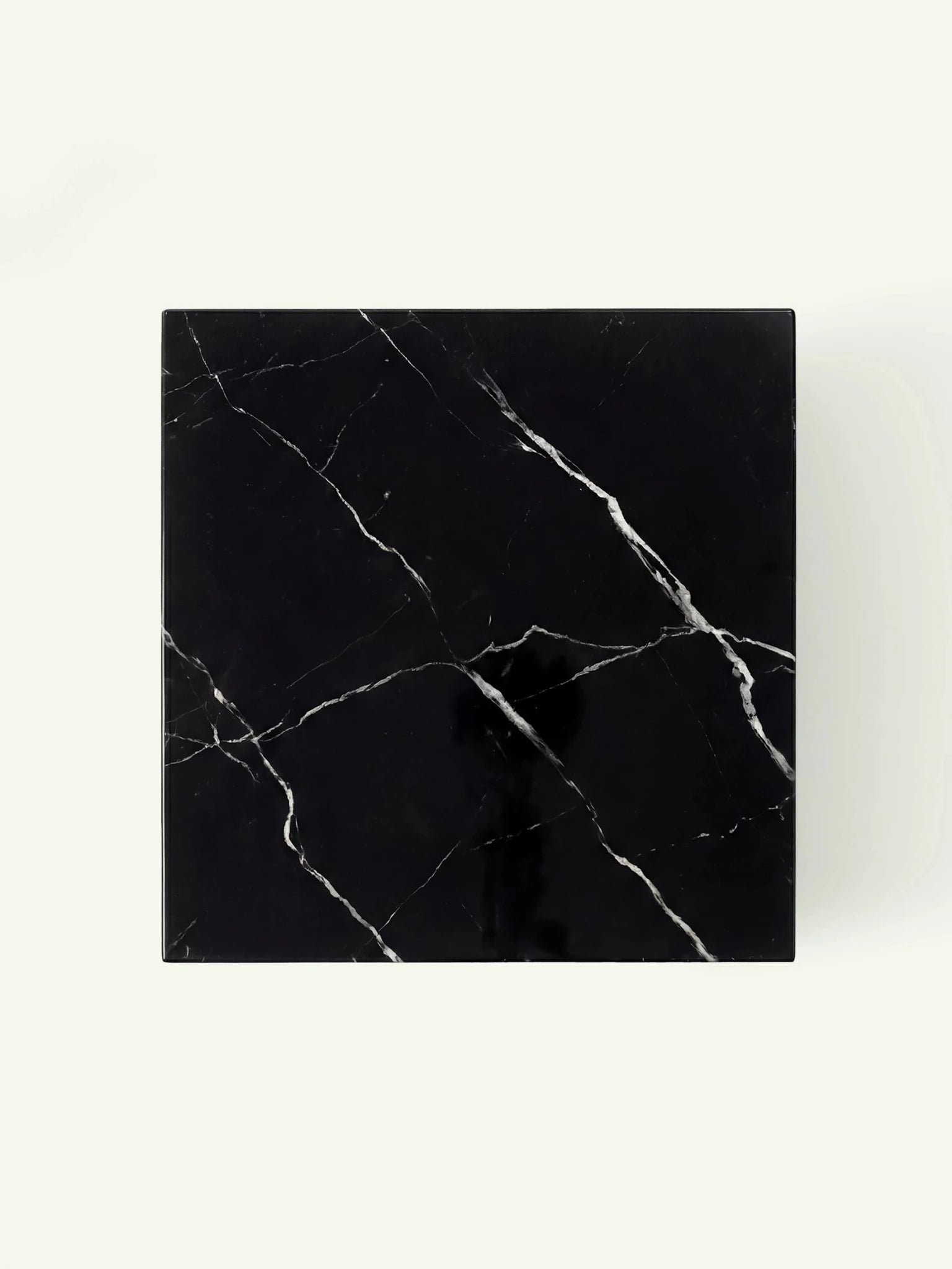 Blick direkt von oben auf die quadratische Tischplatte aus Nero Marquina Marmor mit charakteristischer weißer Maserung.