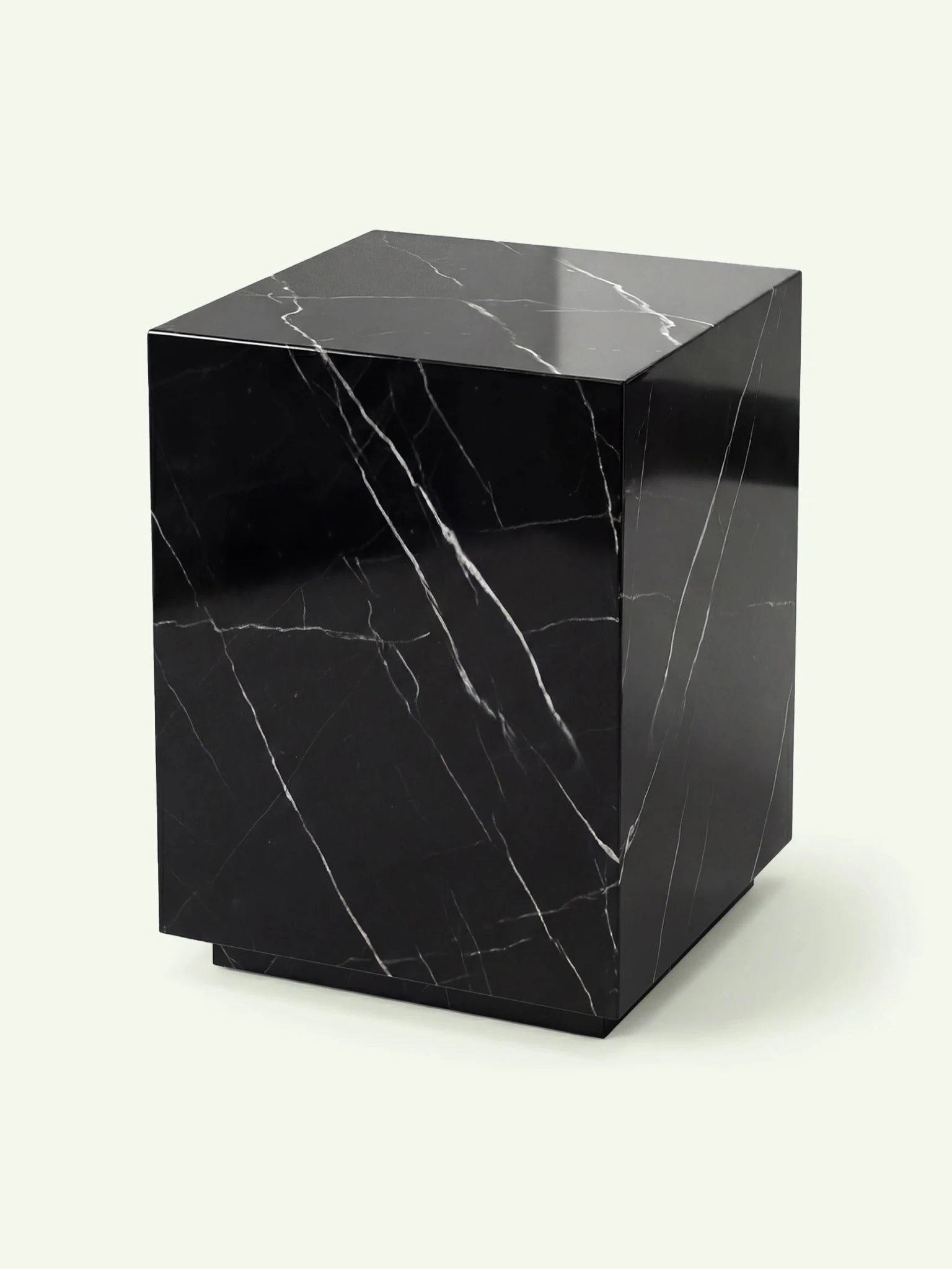 Perspektivische Ansicht des Marmortischs Pella in Nero Marquina, die die kubische Form und die polierte Oberfläche betont.