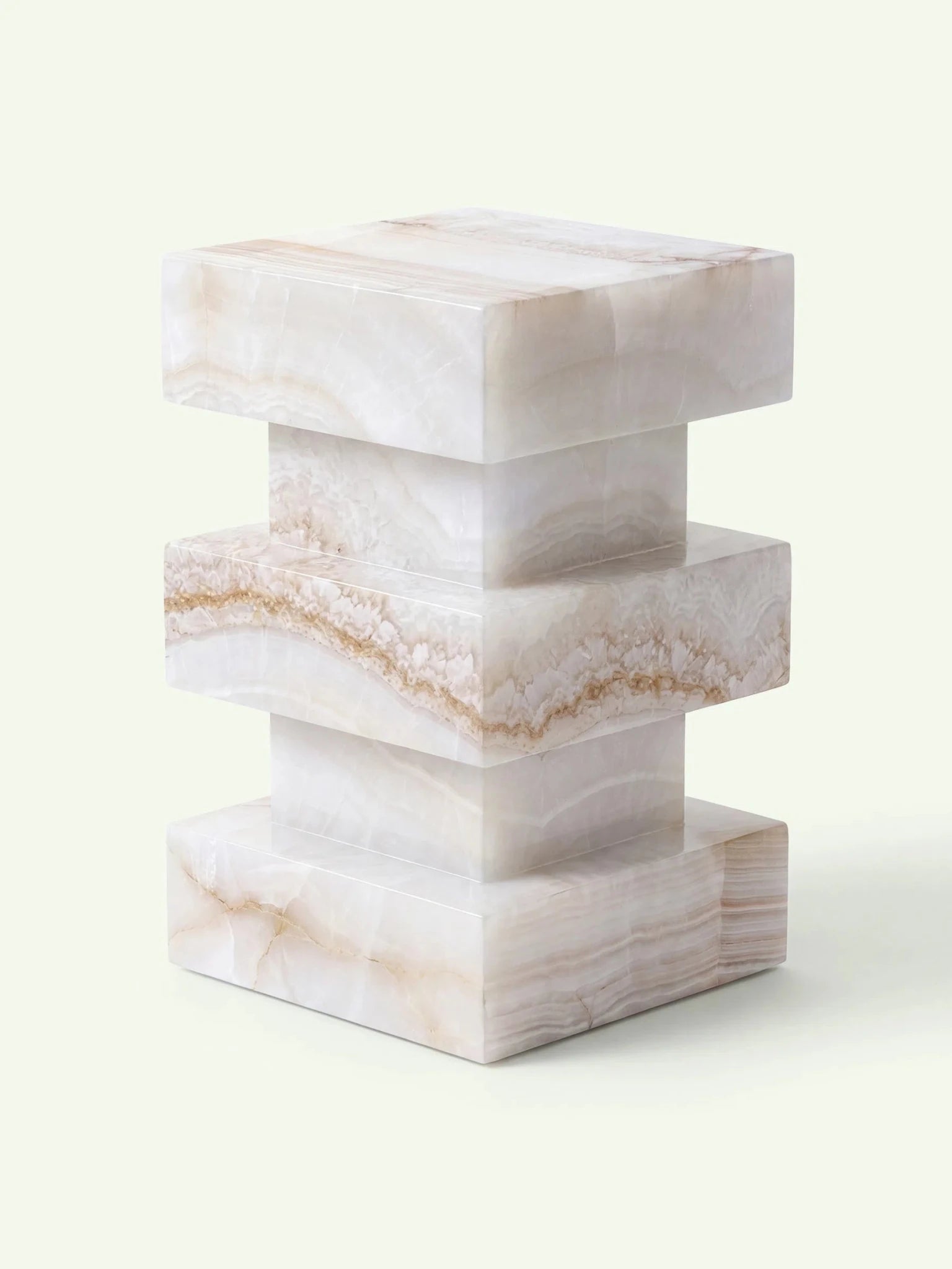 Dreidimensionale Ansicht des Onyx-Beistelltischs Monue, die die architektonische Struktur und die transluzente Optik des weißen Natursteins betont.