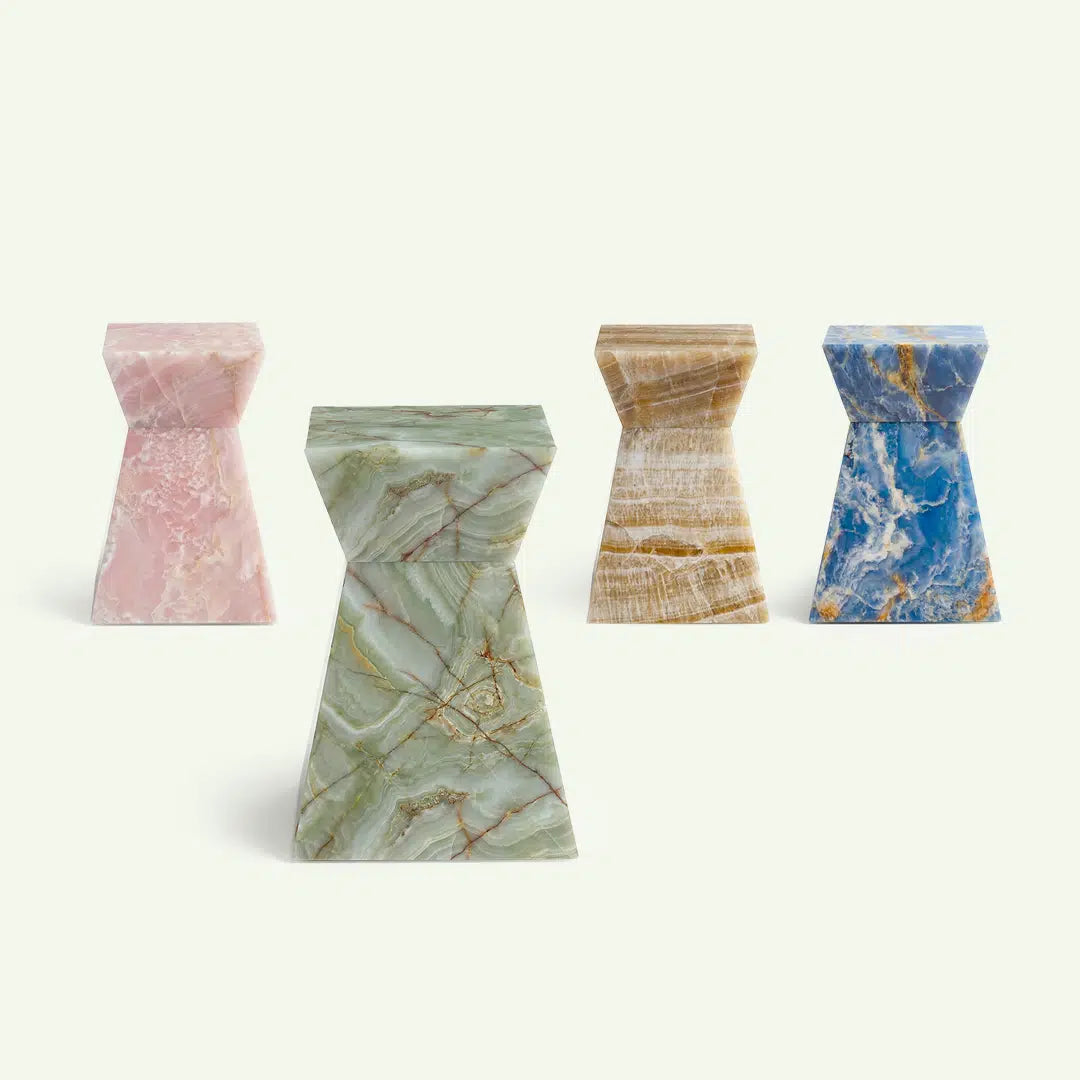 Gruppenaufnahme der Suela Onyx-Serie mit Fokus auf das Modell in grünem Onyx im Vordergrund. Dahinter sind zur Übersicht die Varianten in Rose Onyx, Honig-Onyx und Blue Onyx aufgereiht, um die Farbauswahl der Kollektion zu zeigen.