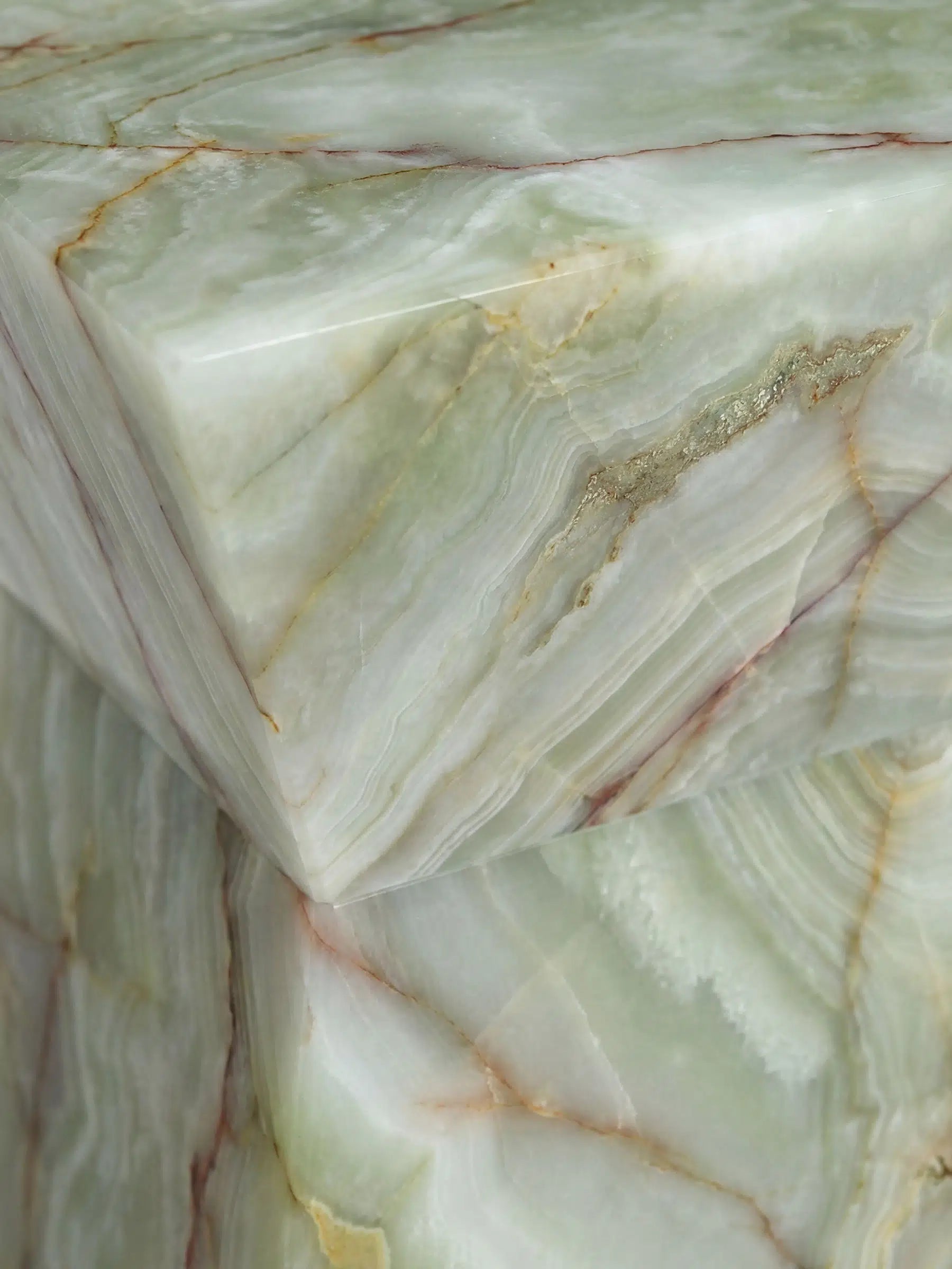 Detailaufnahme der natürlichen Schichtung und der kristallinen Textur des grünen Onyx-Natursteins.