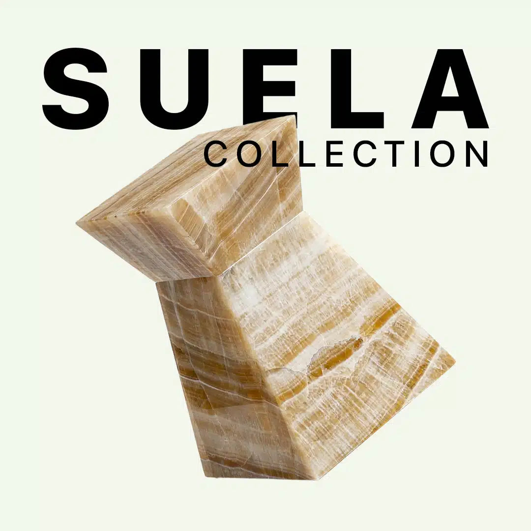 Grafische Präsentation der Suela Collection von Menelame mit dem skulpturalen Beistelltisch aus Honig-Onyx. Das Bild zeigt die warme, bernsteinfarbene Transluzenz und die feinen weißen Aderungen des Natursteins vor dem Kollektions-Schriftzug.