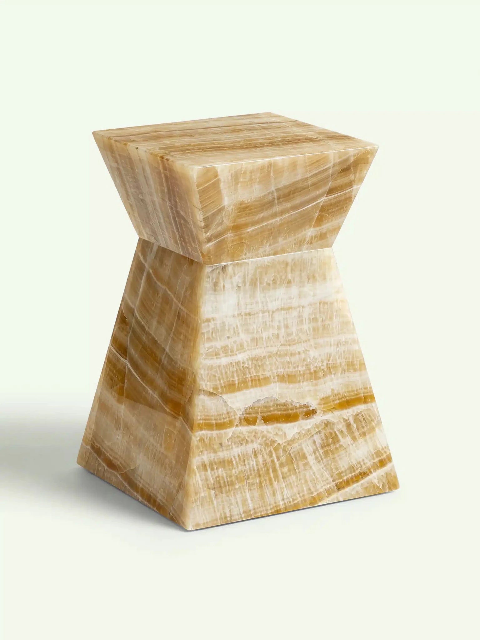 Perspektivische Ansicht des Onyx-Tisches Suela, die die warmen Gelb- und Goldtöne sowie die geometrische Struktur hervorhebt.