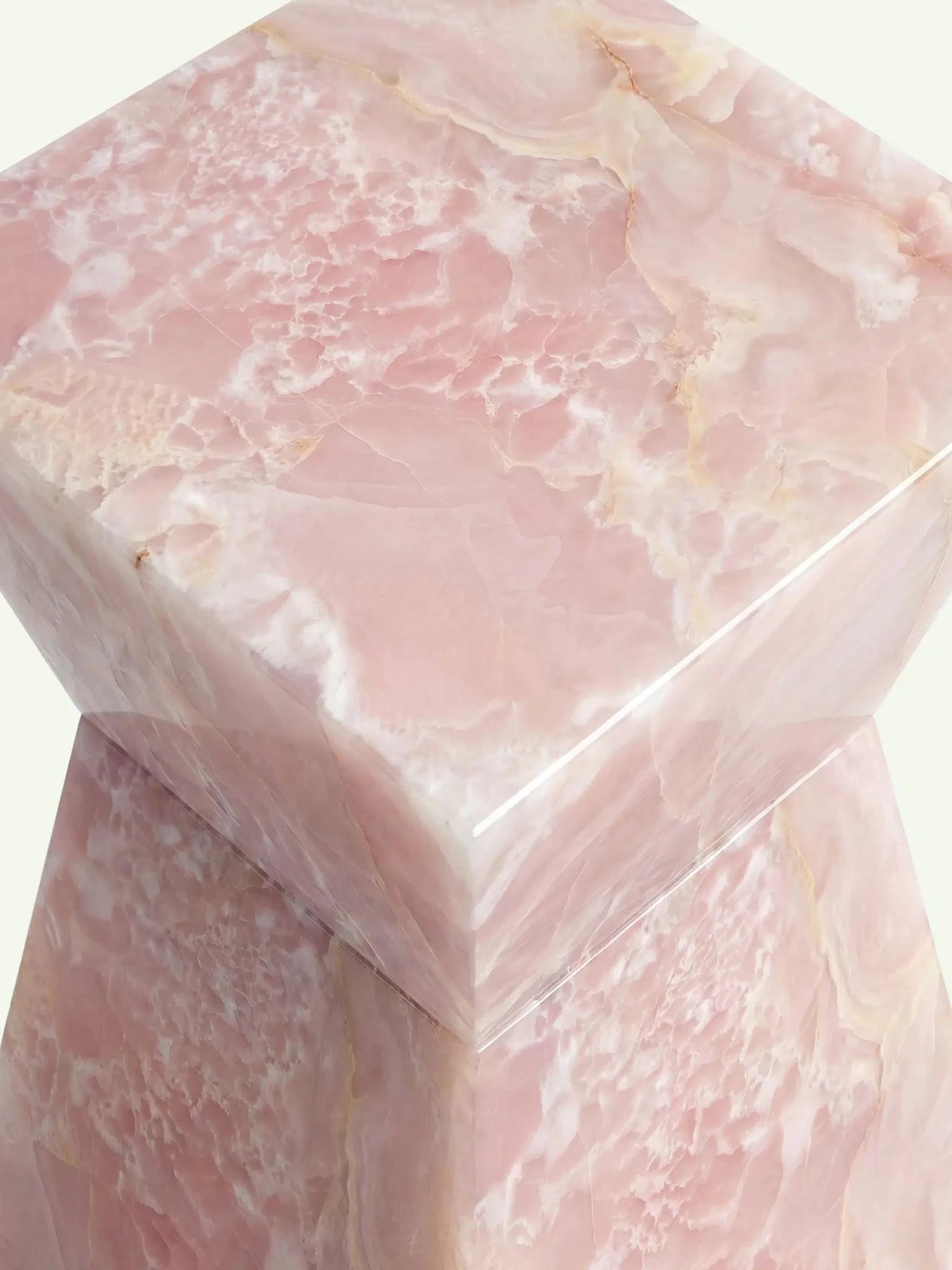 Nahaufnahme der oberen Ecke des Modells Suela, die die hochwertige Hochglanzpolitur des rosa Onyx-Natursteins zeigt.