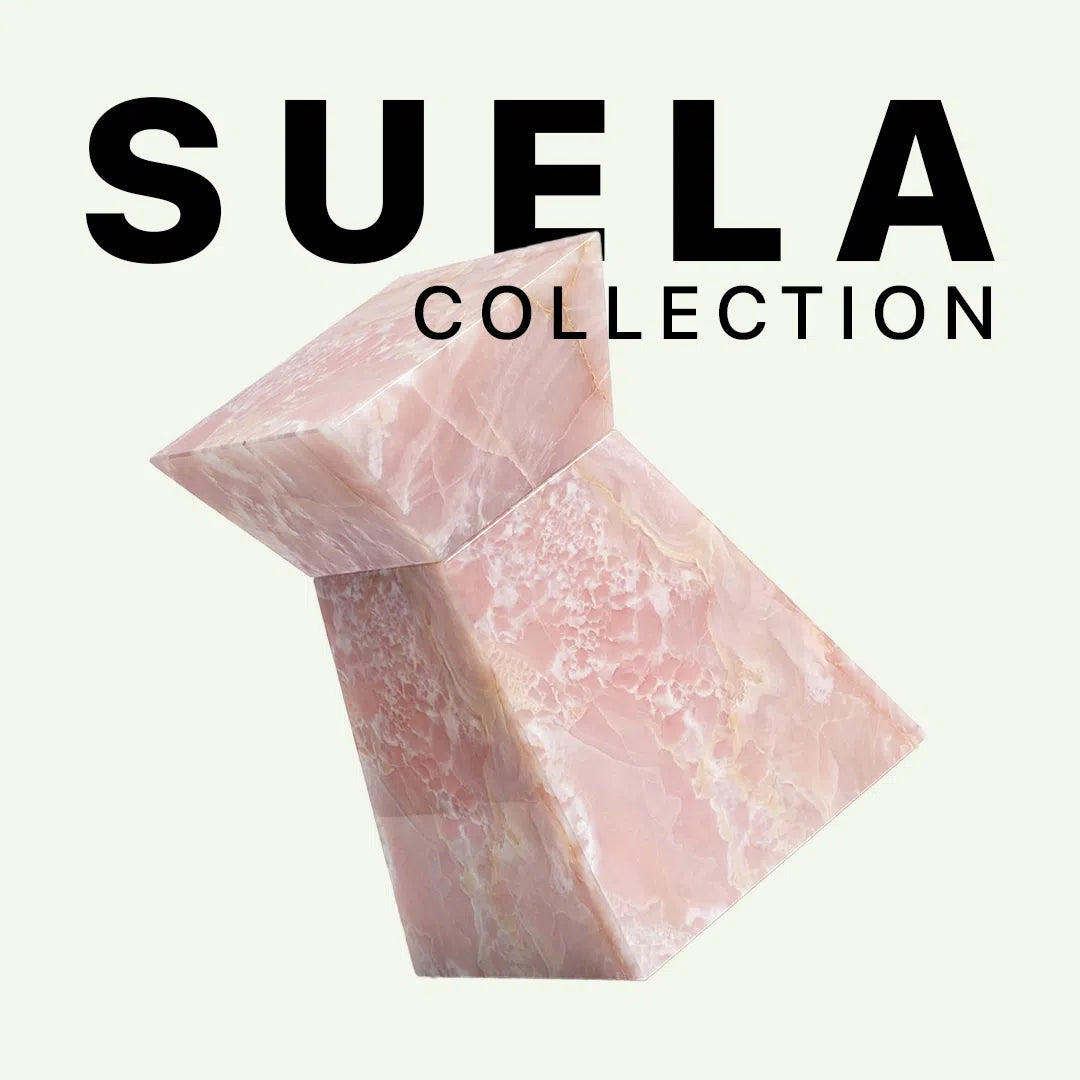 Werbebild für die Suela Collection von Menelame. Der Fokus liegt auf dem skulpturalen Beistelltisch aus zartrosa Rose Onyx. Die Grafik zeigt die edle, kristalline Struktur des Steins vor einem neutralen Hintergrund mit dem Markenschriftzug.