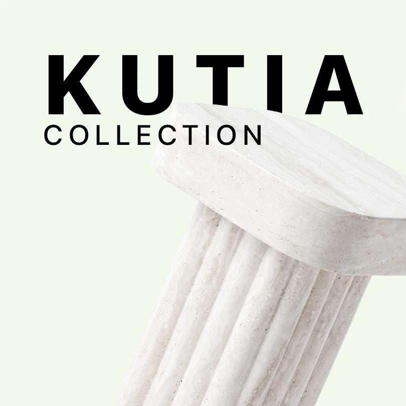 Werbegrafik für den Kutia Beistelltisch von Menelame. Das Bild zeigt den oberen Teil des Tisches aus super weißem Travertin mit seiner kannelierten Säulenbasis und der massiven Tischplatte vor dem „Kutia Collection“ Schriftzug.