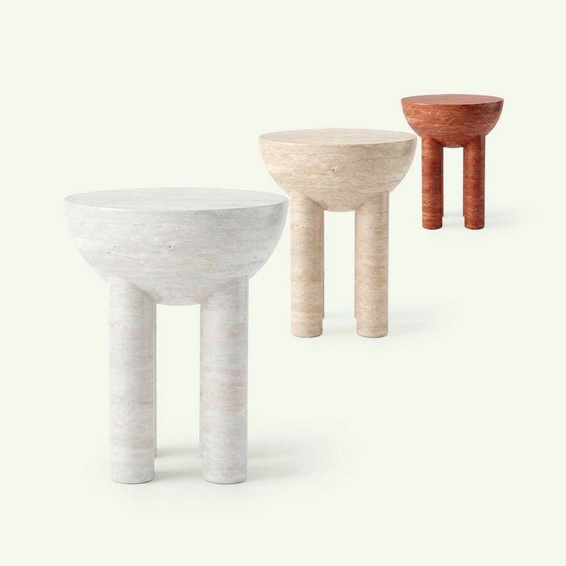 Gruppenaufnahme der Lugo Beistelltisch-Serie. Im Vordergrund steht das Modell aus super weißem Travertin, gefolgt von den Varianten in beigem und rotem Travertin, um die Material- und Farbauswahl der Kollektion zu präsentieren.