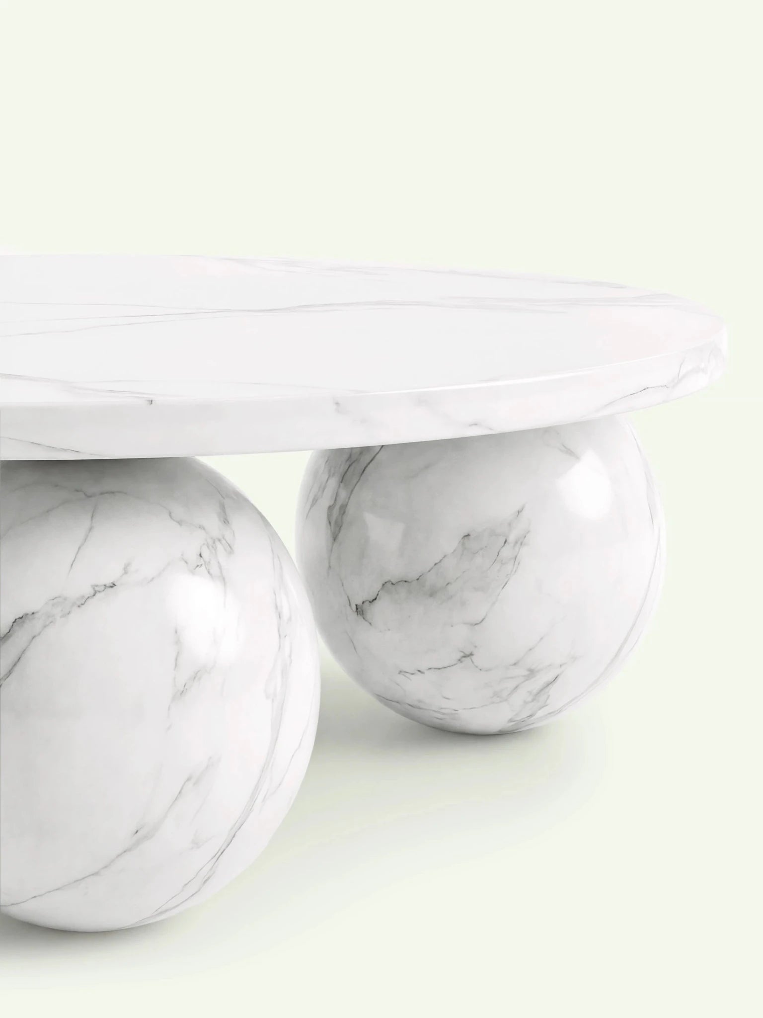 Nahaufnahme der flachen Marmorplatte und eines kugelförmigen Standfußes beim Modell Belnor in Calacatta White.