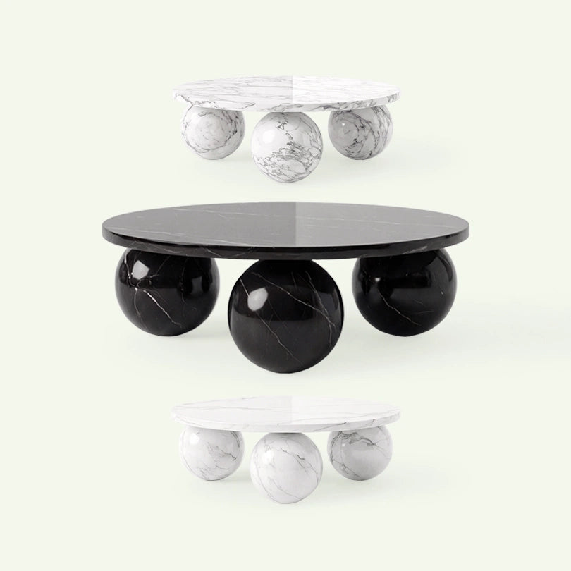 Frontale Übersicht der Belnor Couchtisch-Serie. Im Zentrum steht das Modell aus schwarzem Nero Marquina Marmor, umgeben von den Arabescato-Varianten in verschiedenen Größen, um die Materialvielfalt der Kugelfuß-Kollektion zu zeigen.