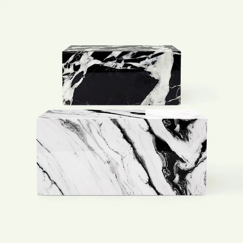 Frontale Übersicht der Lissu Couchtisch-Serie. Im Fokus steht die helle Variante aus Panda White Marmor, dahinter ist das Modell in Grande Antique Marmor zur Veranschaulichung der verschiedenen Naturstein-Optiken aufgereiht.