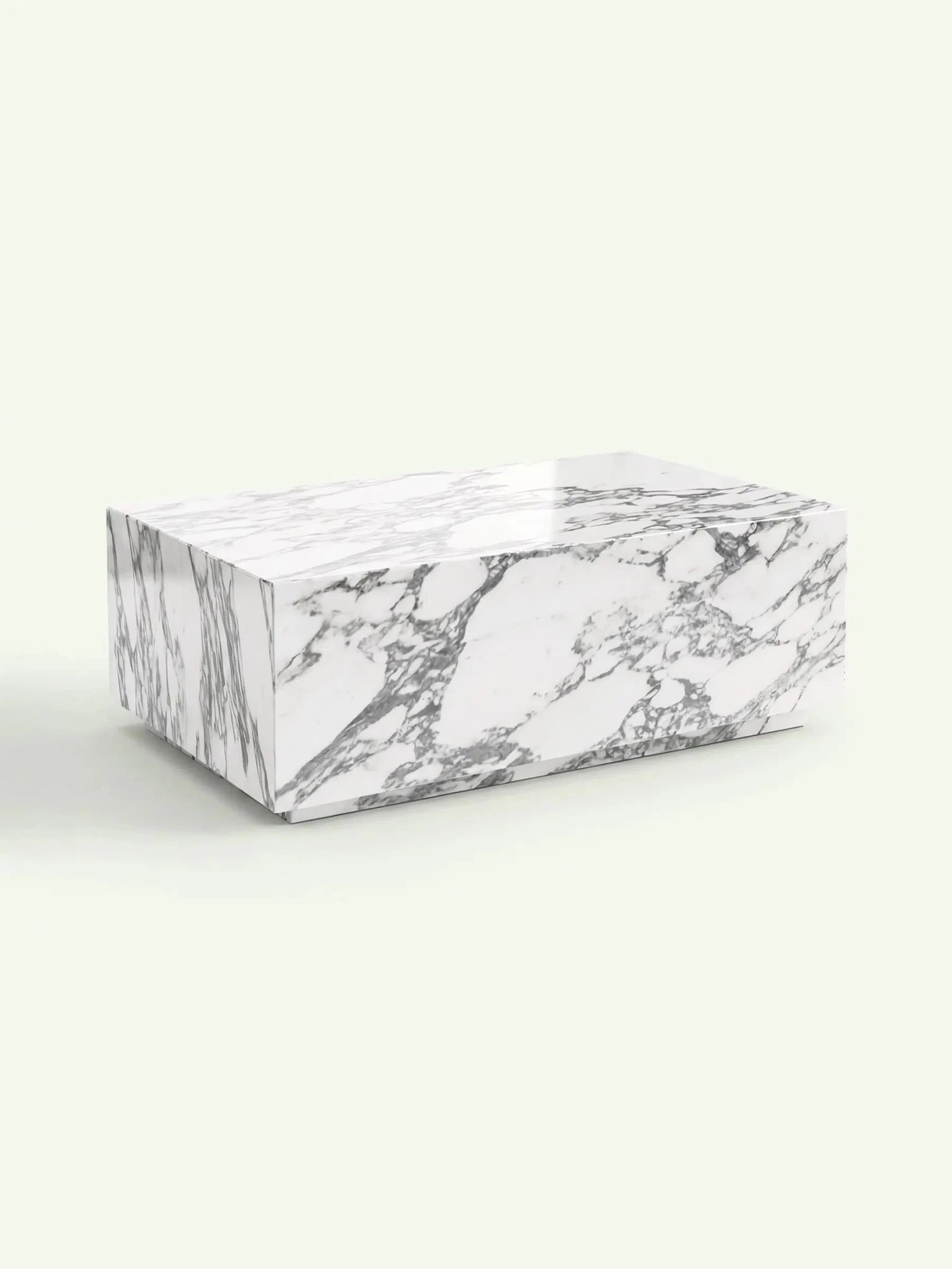 Eine perspektivische 3D-Darstellung des Madena Couchtischs. Die Aufnahme betont die massive Blockform und die lebhafte Arabescato-Marmorierung, die sich über die gesamte Oberfläche und die Seitenwände des Tisches erstreckt.
