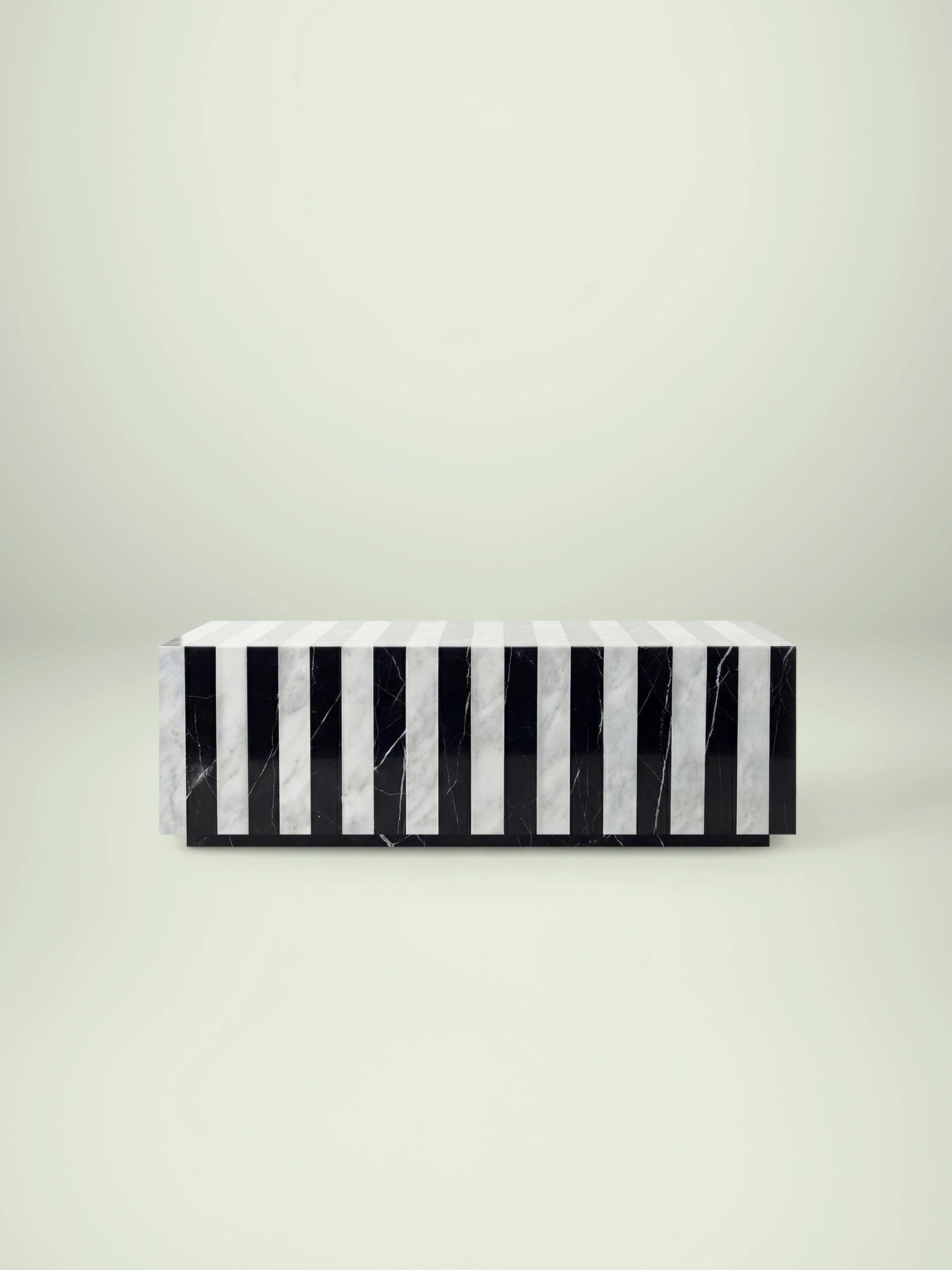 Frontale Ansicht des Madena Couchtischs von Menelame im Zebra-Design. Die abwechselnden vertikalen Streifen aus weißem Carrara Marmor und schwarzem Nero Marquina Marmor erzeugen einen modernen, grafischen Look.