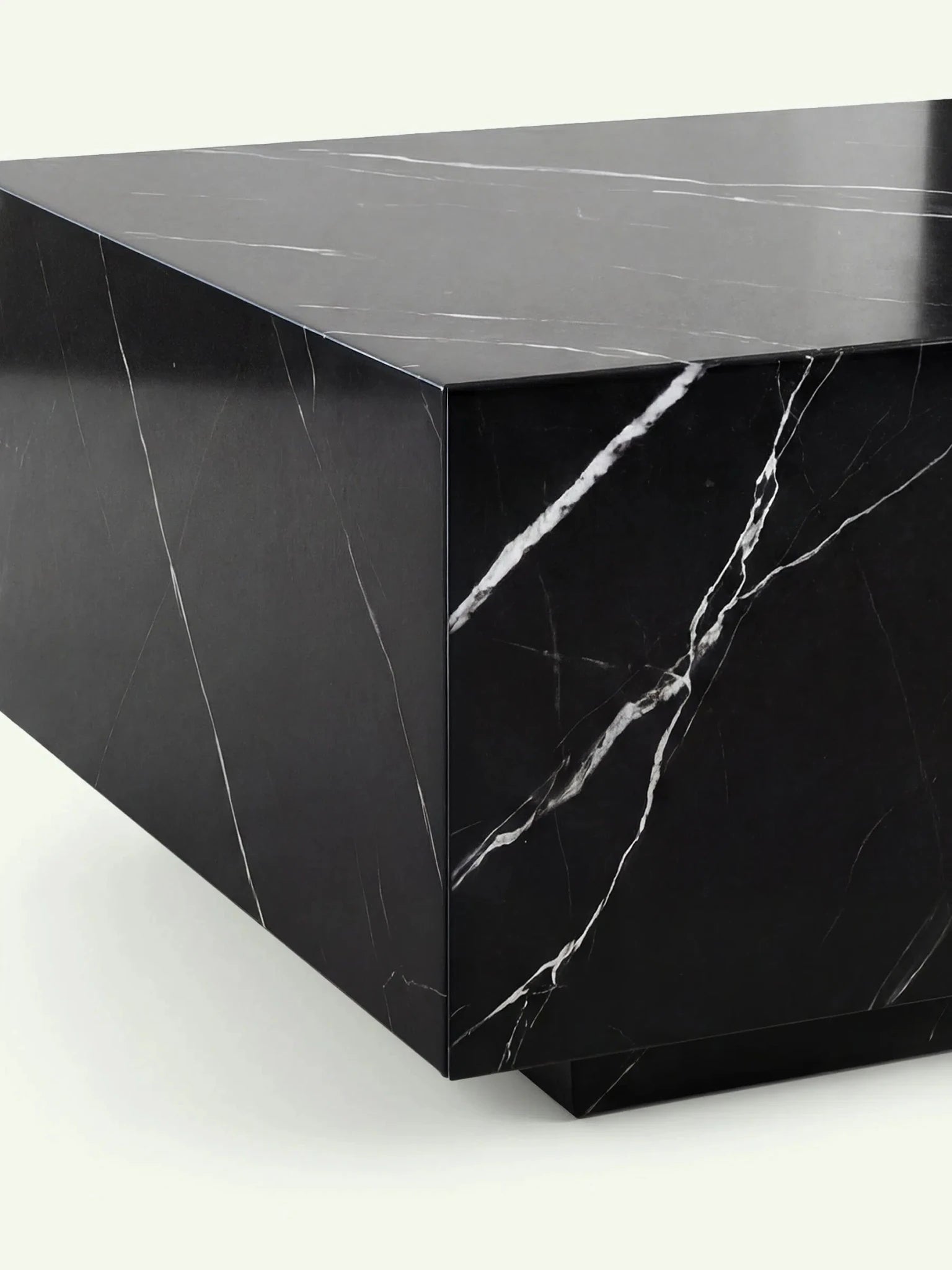 Detailaufnahme der oberen Ecke des Madena Marmortischs. Die Nahaufnahme zeigt die präzise 45-Grad-Gehrung und den Kontrast zwischen dem polierten schwarzen Nero Marquina Marmor und den markanten weißen Adern.