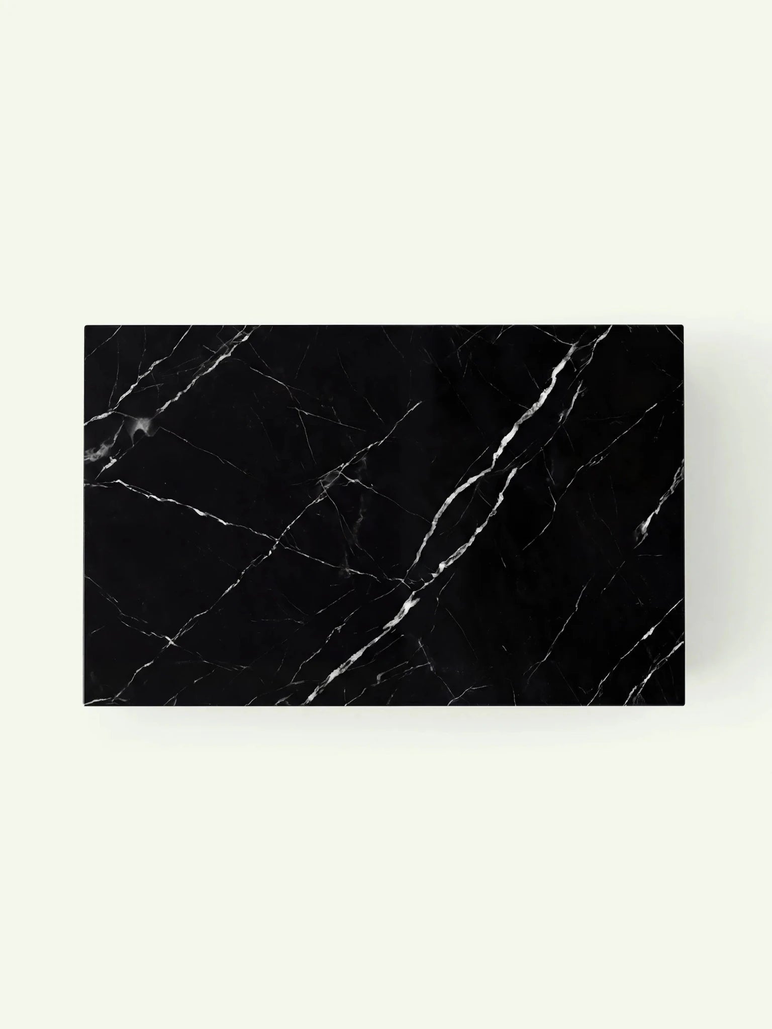 Draufsicht auf die Tischplatte des Madena Couchtischs. Die Oberfläche aus Nero Marquina Marmor präsentiert ein natürliches Muster aus diagonal verlaufenden weißen Adern auf tiefschwarzem Untergrund.