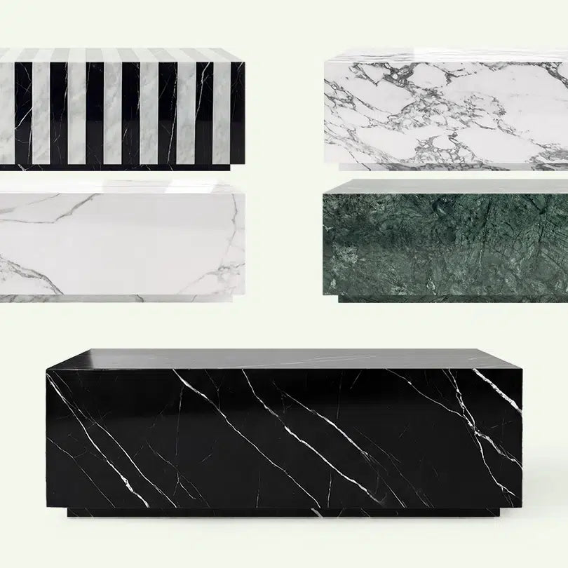 Frontale Übersicht der Madena Couchtisch-Kollektion. Im Vordergrund steht das Modell aus tiefschwarzem Nero Marquina Marmor, umgeben von den Ausführungen in Arabescato, Calacatta White, Verde Guatemala und dem gestreiften Zebra-Design.