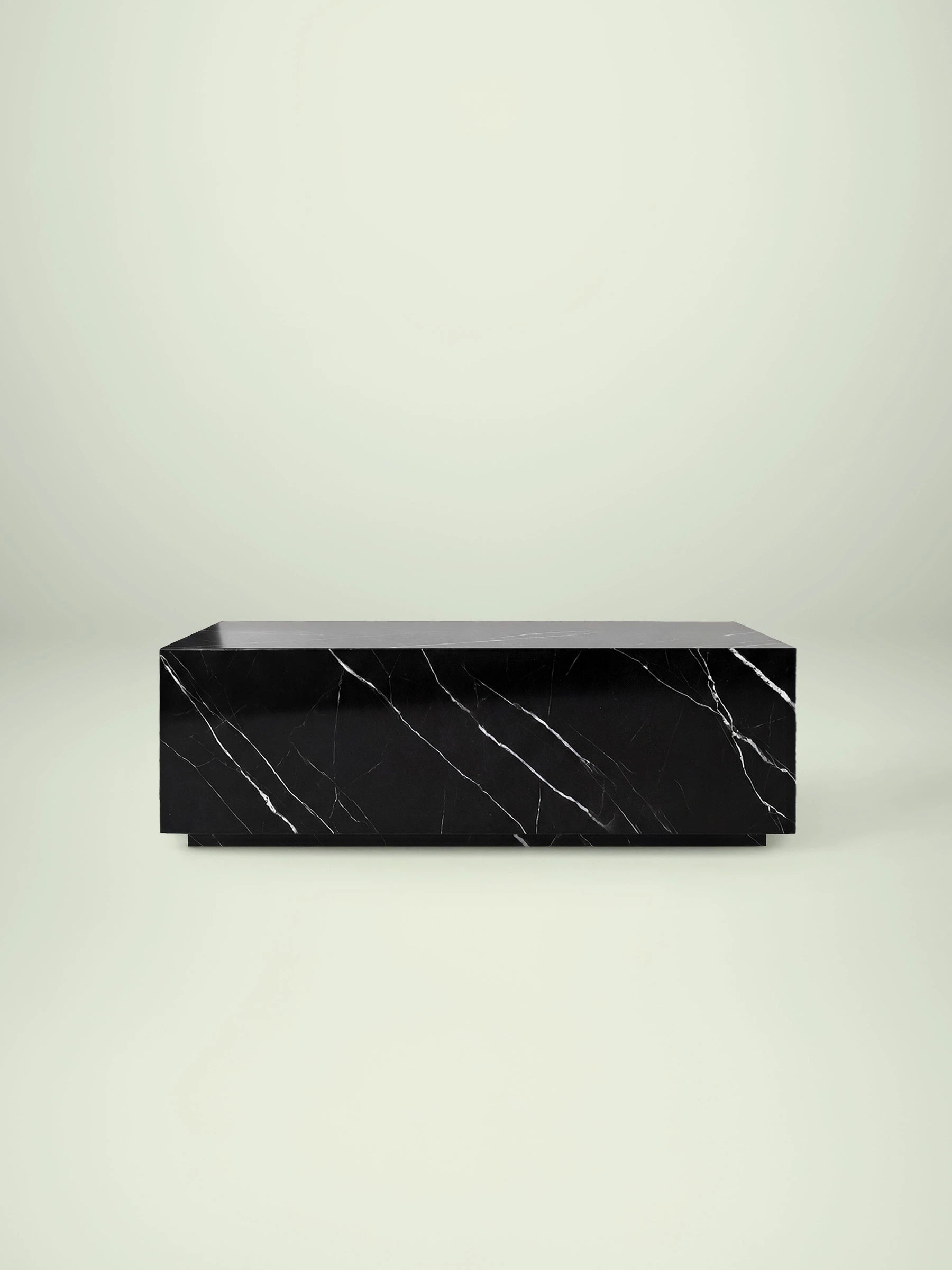 Frontalansicht des rechteckigen Madena Couchtischs von Menelame aus tiefschwarzem Nero Marquina Marmor. Das minimalistische Monolith-Design besticht durch seine feinen, weißen Kalkaderungen auf dunklem Grund.