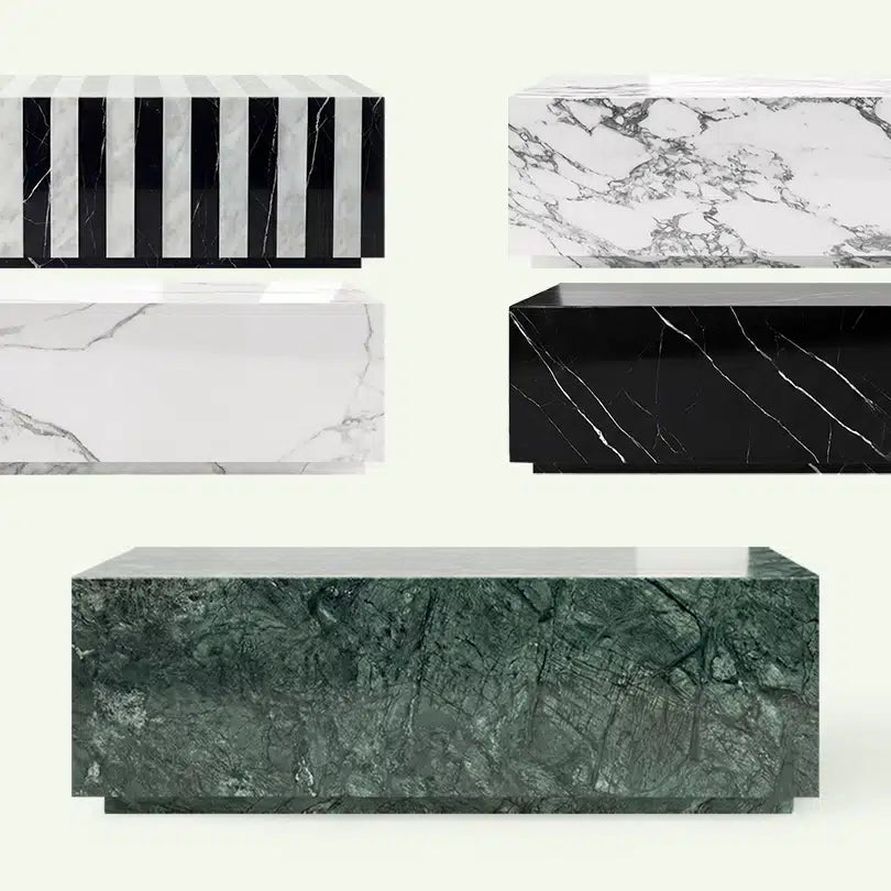 Frontale Übersicht der Madena Couchtisch-Kollektion. Im Vordergrund steht das Modell aus grünem Verde Guatemala Marmor, umgeben von den Varianten in Arabescato, Calacatta White, Nero Marquina und dem gestreiften Carrara-Mix.