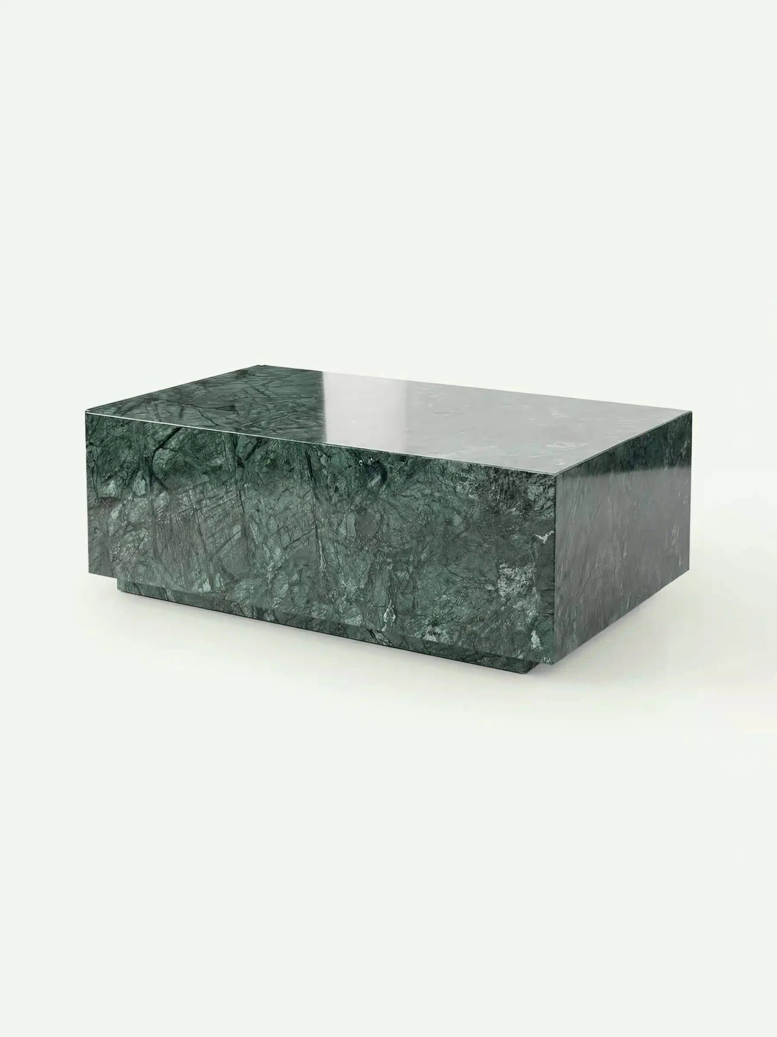 Eine perspektivische 3D-Ansicht des Madena Couchtischs in Verde Guatemala Marmor. Die Aufnahme zeigt die kubische Form und den schwebenden Sockel, während das Licht die polierte, tiefgrüne Marmoroberfläche elegant betont.