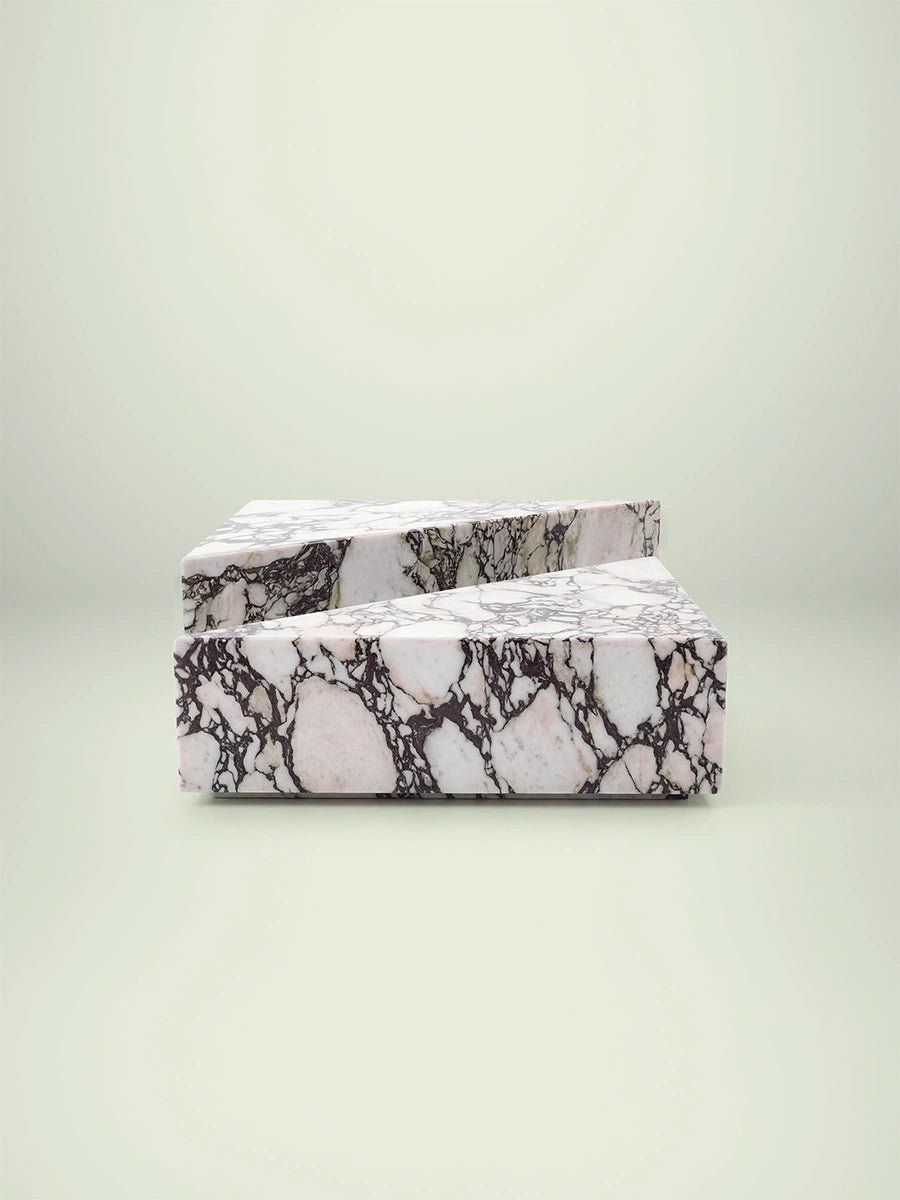 Frontale Studioaufnahme des Sokala Couchtischs von Menelame. Die zwei geometrischen Marmorblöcke aus Calacatta Viola stehen präzise voreinander und bilden ein skulpturales Design-Objekt im Raum.