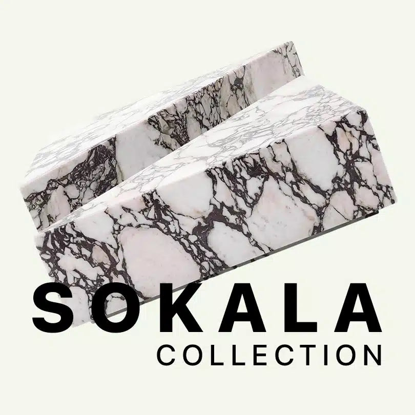 Werbegrafik für die Sokala Collection von Menelame. Zu sehen ist eine Detailansicht des zweiteiligen Couchtischs aus Calacatta Viola Marmor mit seiner charakteristischen weinroten Maserung auf hellem Grund vor dem Markenschriftzug.