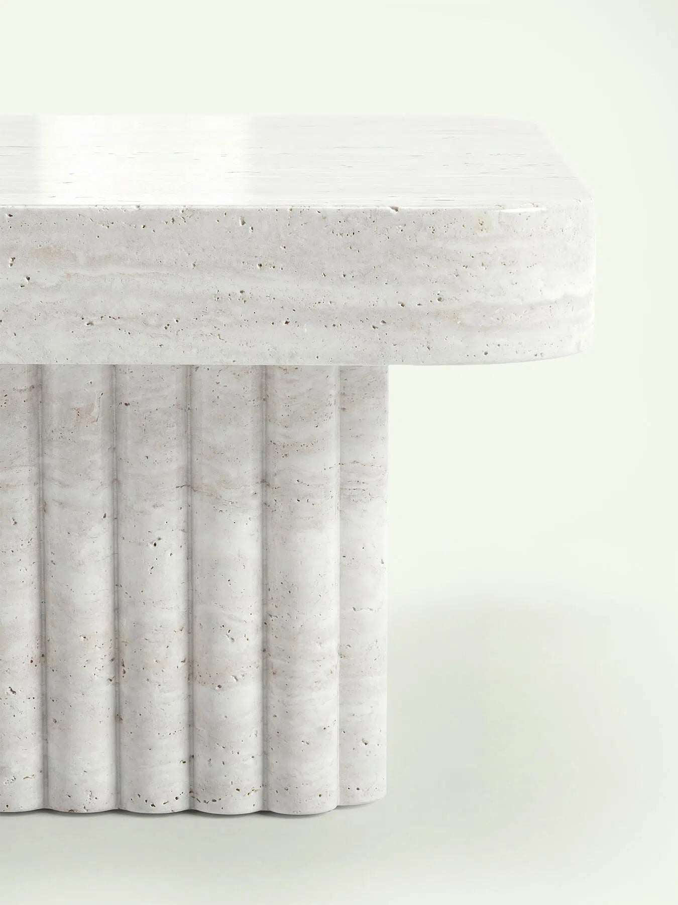 Detailaufnahme der kannelierten Oberfläche am massiven Standfuß des Couchtischs Kutio aus Super Weiß Travertin.