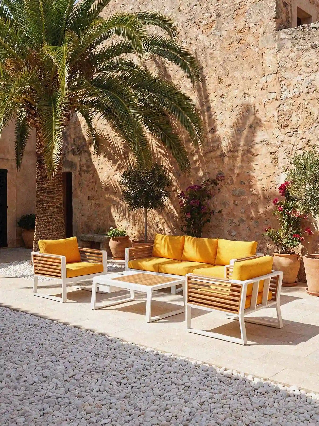 Mediterrane Terrassengestaltung mit dem Menelamé Lounge-Set Balin, honiggelbe Polster kombiniert mit weißem Aluminium und Teakholz-Details.