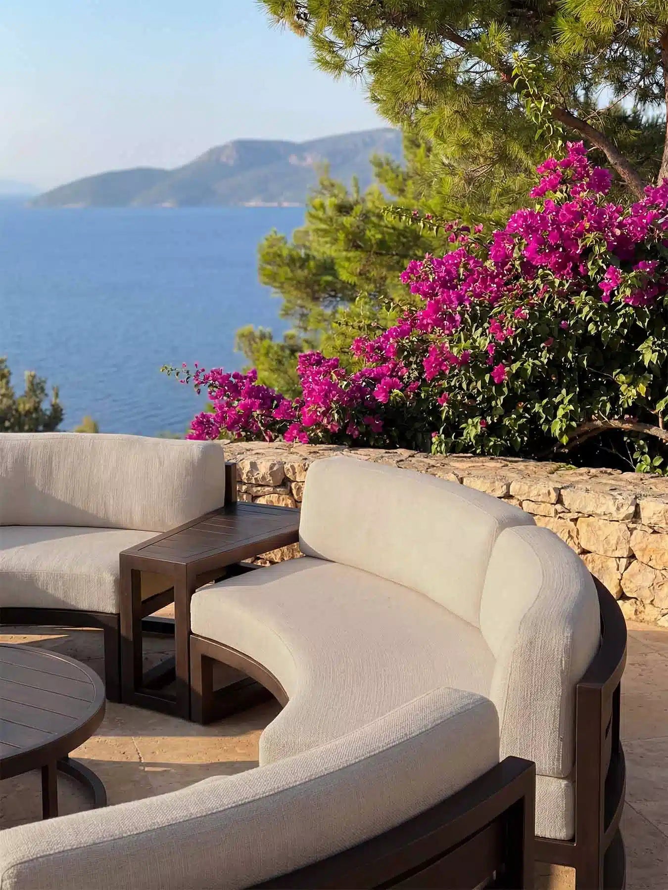 Rückansicht der Menelamé Bresa Outdoor-Lounge auf einer Terrasse, Fokus auf das schwarze Aluminium-Liniendesign.