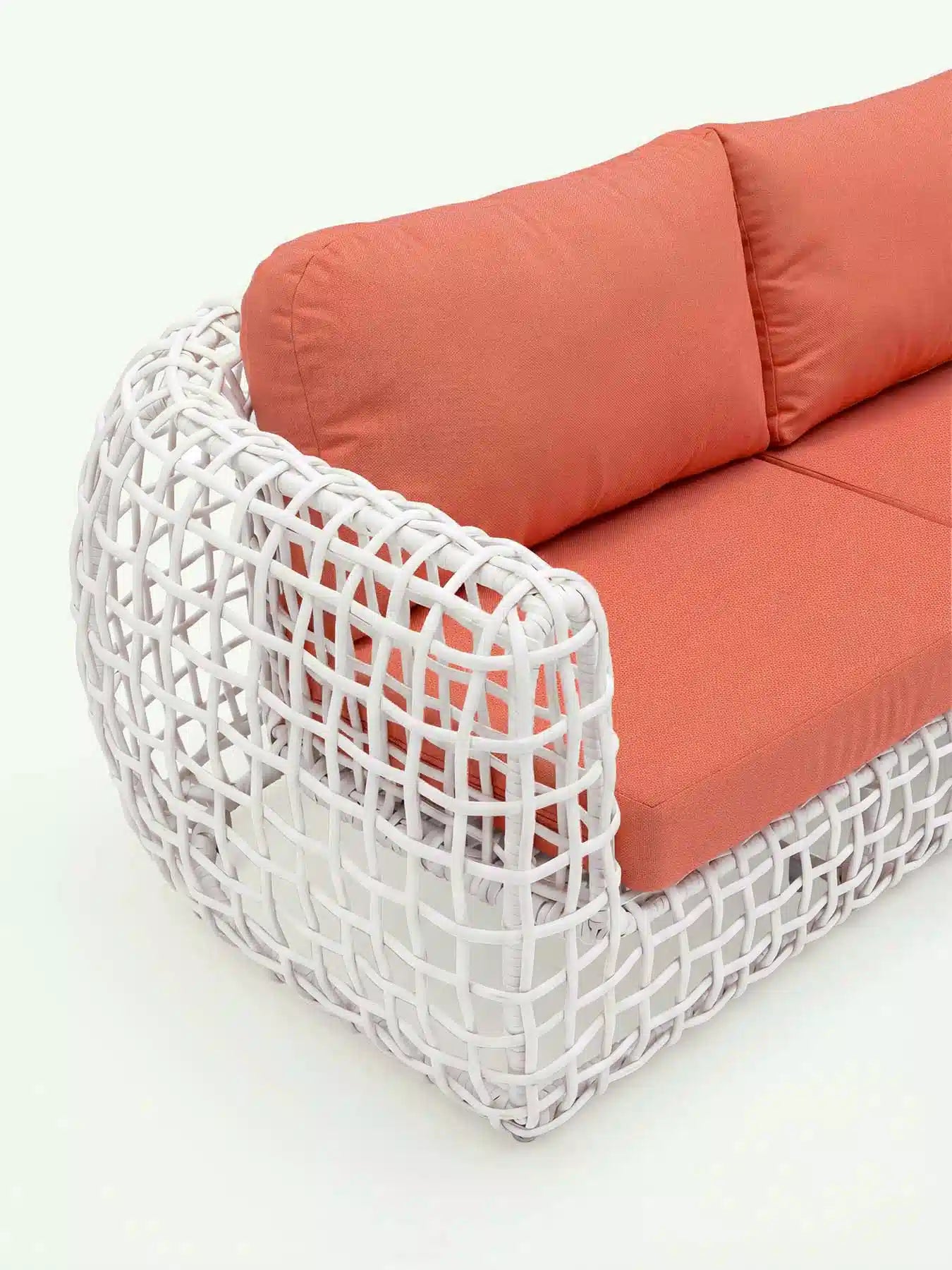 Detailansicht des weißen Rattan-Geflechts und der korallenroten Textur der Menelamé Lounge Durnes.