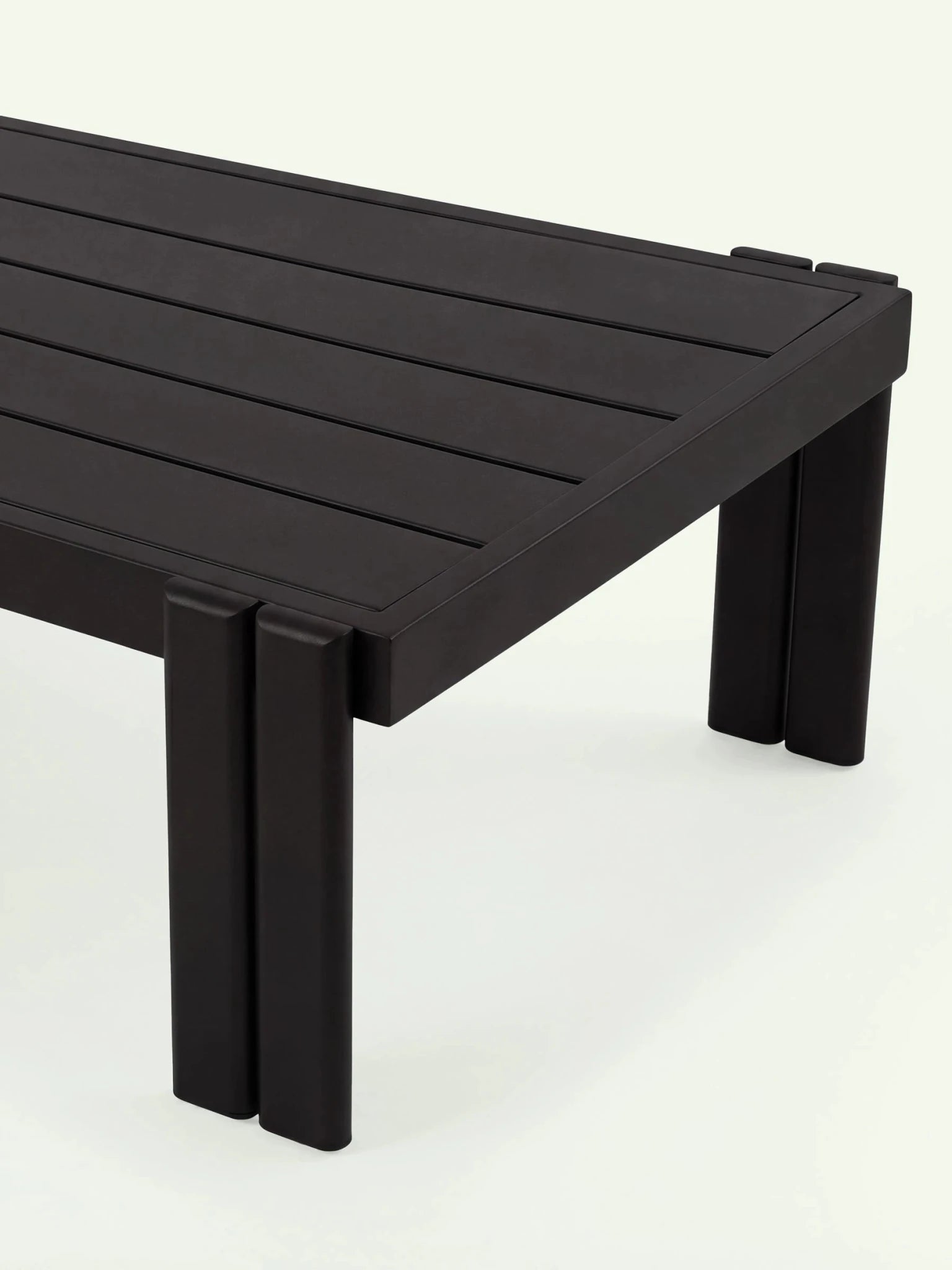 Nahaufnahme der schwarzen Aluminium-Tischplatte und des markanten Fußdesigns der Menelamé Kilim Outdoor-Kollektion.