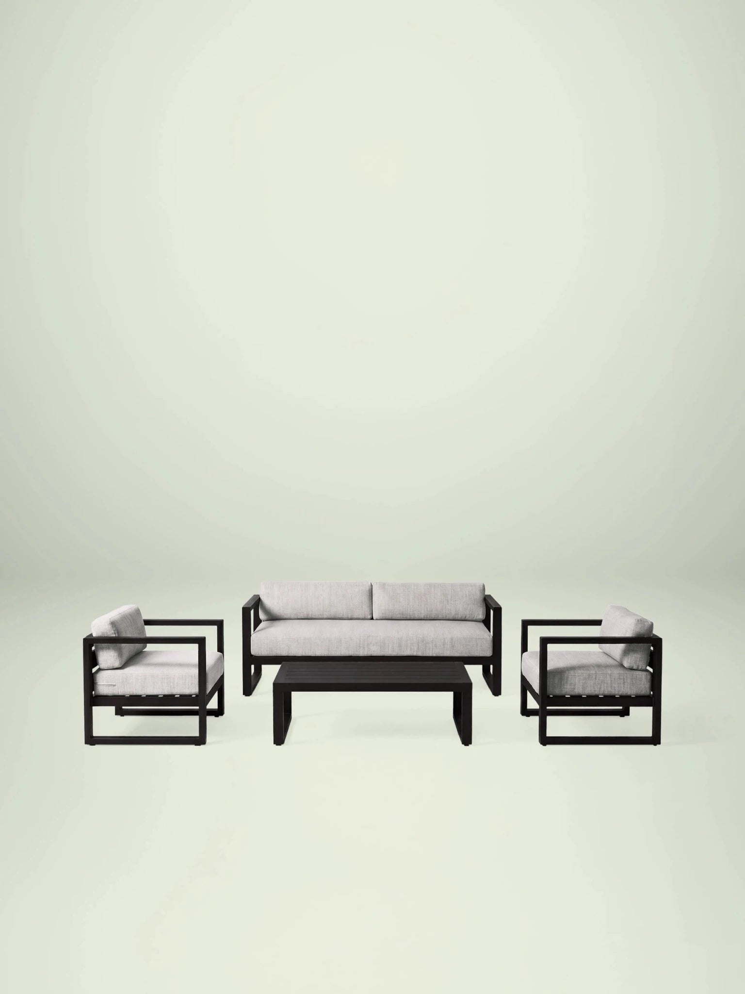 Menelamé Garten-Lounge-Set Lendin: Schwarzes Aluminium-Sofa und Sessel mit hellgrau melierten Olefin-Kissen.