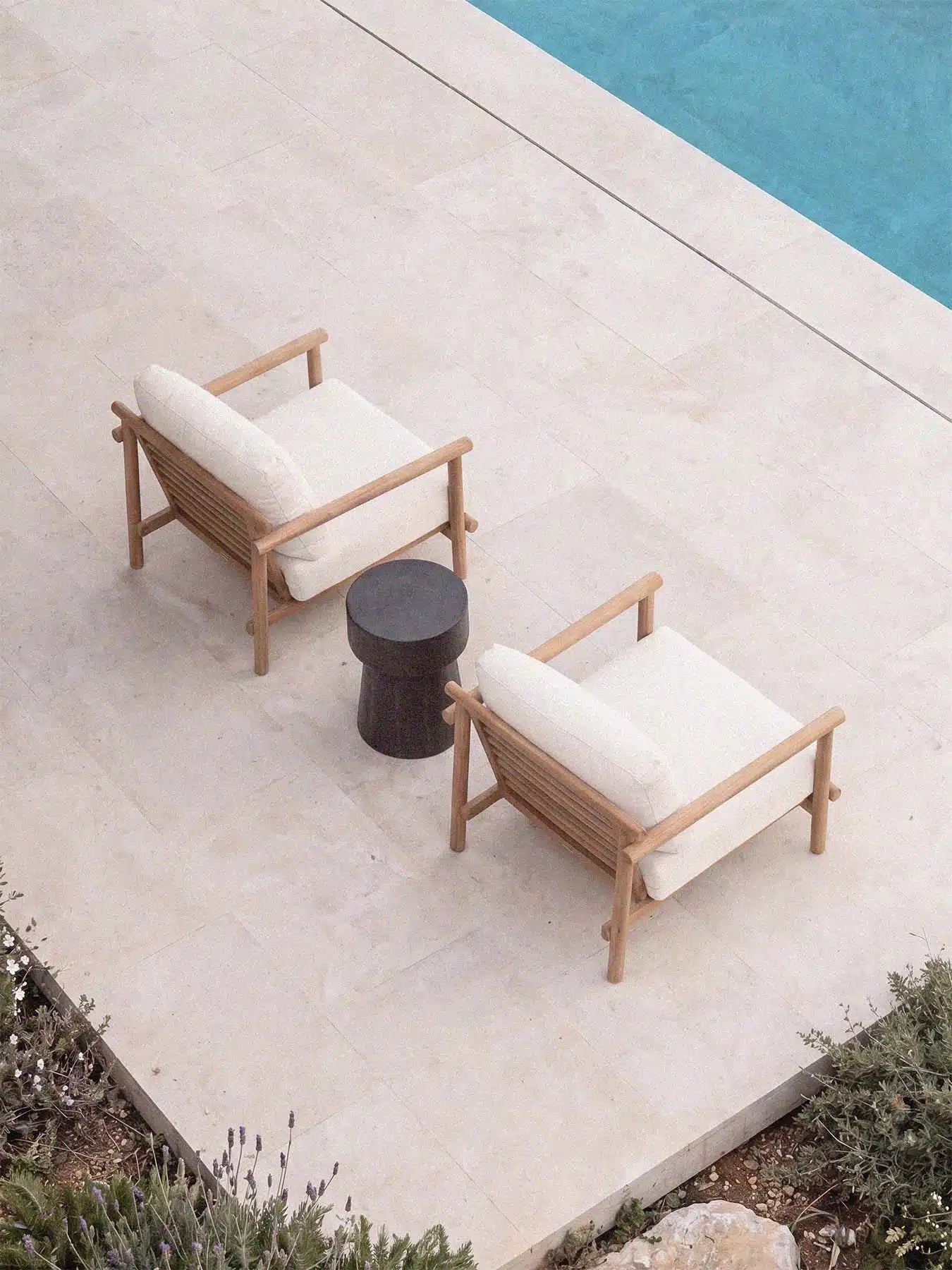 Erhöhte Ansicht der Menelamé Levion Lounge auf Steinterrasse, minimalistisches Gartenmöbel-Design in Weiss und Holz.