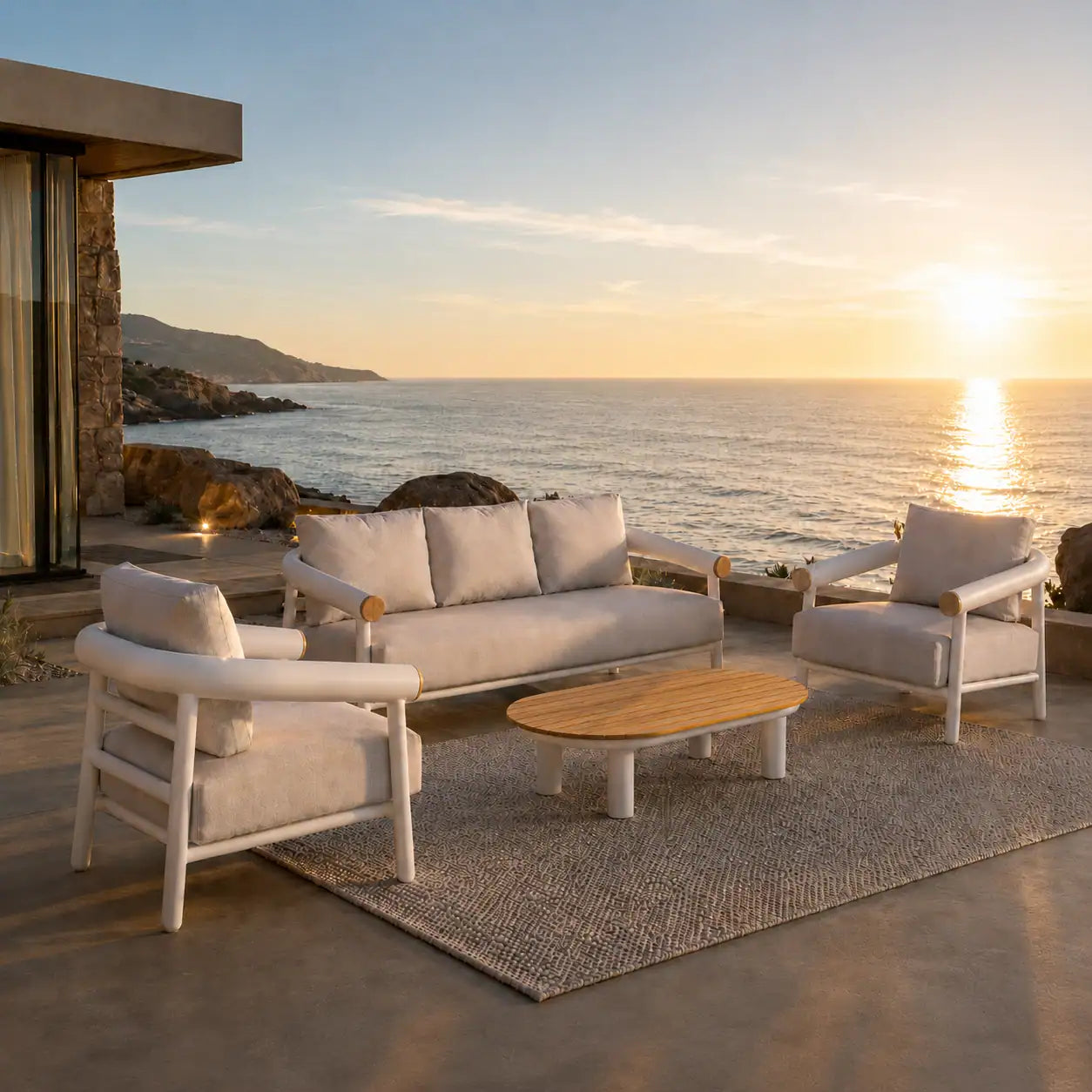 Menelamé Shop by Look: Luxuriöse Gartenlounge auf einer weitläufigen Natursteinterrasse einer exklusiven Villa mit Infinity-Pool und Blick auf eine Meeresbucht in der goldenen Stunde.